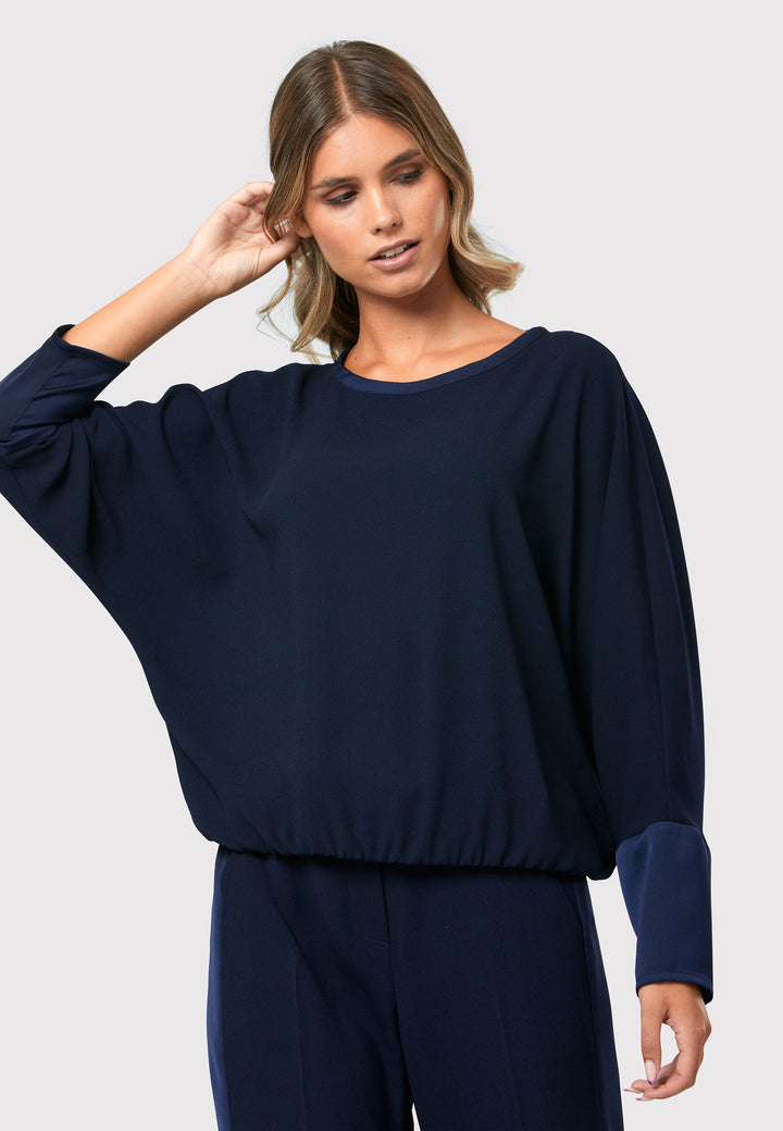 al Midnight Navy Top, a stylish and versatile addition to your wardrobe. Crafted from satin back crepe, it offers a luxurious feel and drapes beautifully. The dropped shoulder design, eleasticated hem and full-length sleeves 