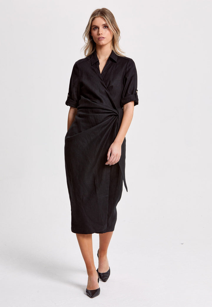 Leonne, the investment-worthy black linen wrap dress. Crafted in a sustainable Irish linen. An authentic wrap dress that ties to the side with a generous belt and flattering gathers at the waist. Engineered with a turned back elbow length sleeve. The ultimate summer staple.
