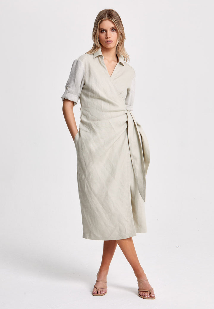 Leonne, the investment-worthy oatmeal linen wrap dress. Crafted in a sustainable Irish linen. An aunthetic wrap dress that ties to the side with a generous belt and flattering gathers at the waist. Engineered with a turned back elbow length sleeve. The ultimate summer staple.