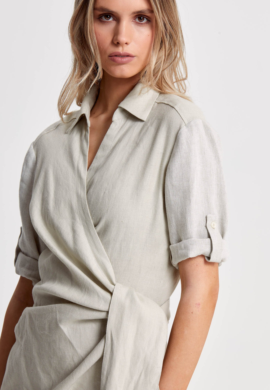 Leonne, the investment-worthy oatmeal linen wrap dress. Crafted in a sustainable Irish linen. An aunthetic wrap dress that ties to the side with a generous belt and flattering gathers at the waist. Engineered with a turned back elbow length sleeve. The ultimate summer staple.