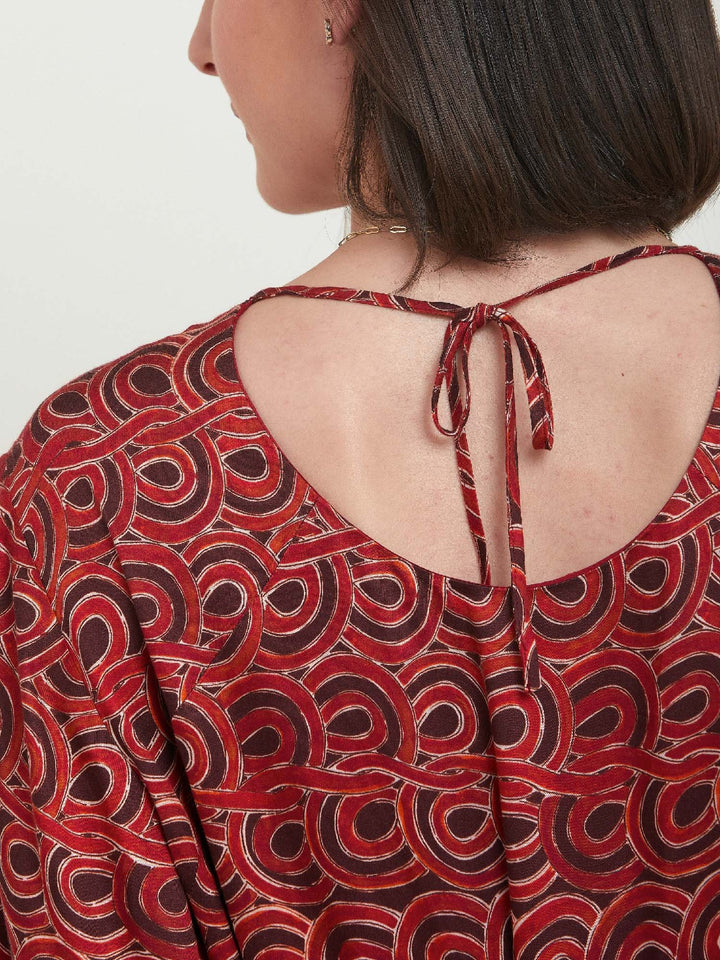 Louis, an easy smock dress. Crafted in a fluid, red & russet tone, abstract print viscose. An empire line dress with handy pockets & a softly gathered two-tier skirt that falls to the mid-calf. Offers a delicate keyhole back neck & a matching belt. Style with a tan boot for a 70's vibe.