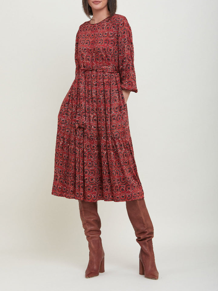 Louis, an easy smock dress. Crafted in a fluid, red & russet tone, abstract print viscose. An empire line dress with handy pockets & a softly gathered two-tier skirt that falls to the mid-calf. Offers a delicate keyhole back neck & a matching belt. Style with a tan boot for a 70's vibe.