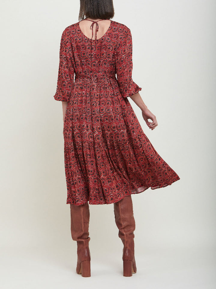 Louis, an easy smock dress. Crafted in a fluid, red & russet tone, abstract print viscose. An empire line dress with handy pockets & a softly gathered two-tier skirt that falls to the mid-calf. Offers a delicate keyhole back neck & a matching belt. Style with a tan boot for a 70's vibe.