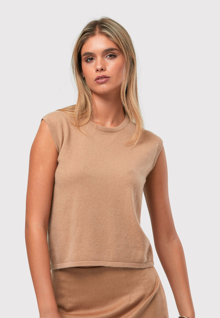 The Marlena Camel Cashmere Sweater-Vest is a sleeveless round-neck top that offers versatile styling options. Wear it as a simple underpinning for the matching ballet wrap to complete a coordinated look. Alternatively, layer it as a sweater vest over your favorite crisp white shirts for a stylish and contemporary outfit. Made from luxurious cashmere, the Marlena Sweater-Vest adds an extra layer of comfort and sophistication to your wardrobe.