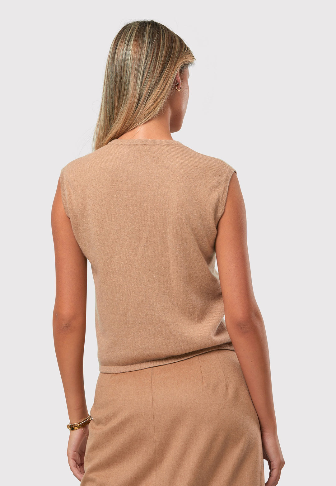 The Marlena Camel Cashmere Sweater-Vest is a sleeveless round-neck top that offers versatile styling options. Wear it as a simple underpinning for the matching ballet wrap to complete a coordinated look. Alternatively, layer it as a sweater vest over your favorite crisp white shirts for a stylish and contemporary outfit. Made from luxurious cashmere, the Marlena Sweater-Vest adds an extra layer of comfort and sophistication to your wardrobe.