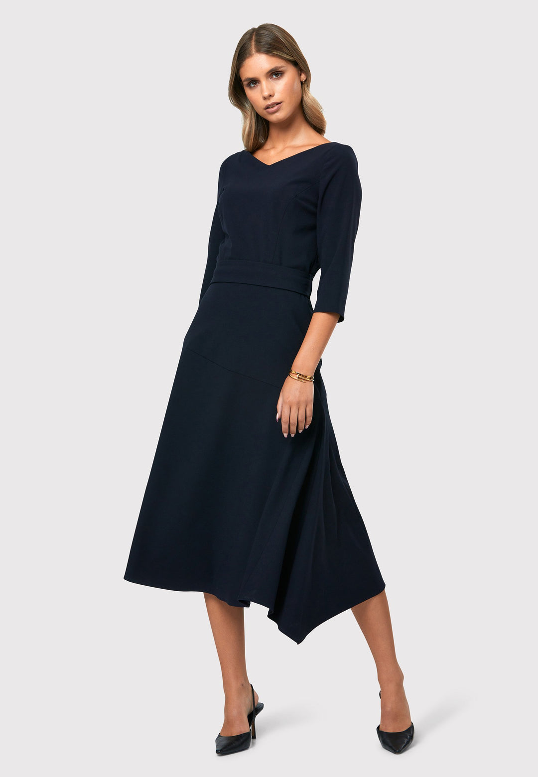 Step into elegance with the Odell Dark Navy Dress, a beautifully tailored and timeless piece. This dress features a detachable belt, fit and flare skirt, and an asymmetrical dipped hem. The wide V-neckline adds sophistication, while the hint of stretch ensures comfort and ease of movement. Whether you're attending a wedding, playing the role of the mother of the bride, or heading to the races, the Odell Dark Navy Dress is the perfect choice for a memorable occasion.