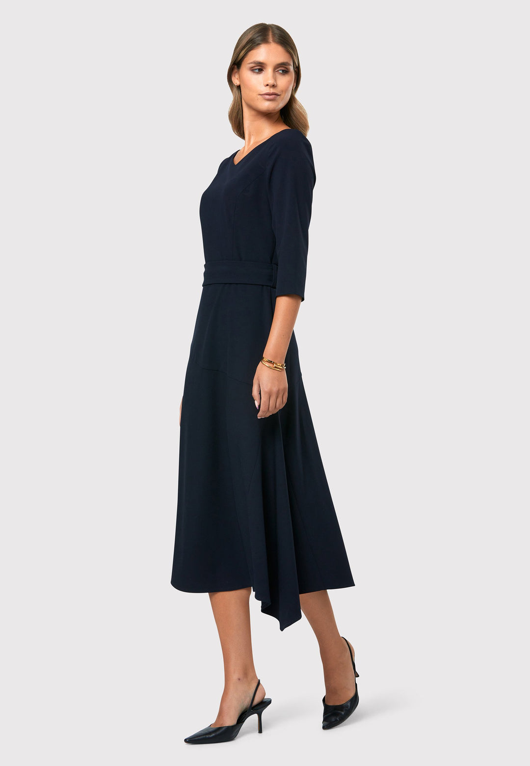 Step into elegance with the Odell Dark Navy Dress, a beautifully tailored and timeless piece. This dress features a detachable belt, fit and flare skirt, and an asymmetrical dipped hem. The wide V-neckline adds sophistication, while the hint of stretch ensures comfort and ease of movement. Whether you're attending a wedding, playing the role of the mother of the bride, or heading to the races, the Odell Dark Navy Dress is the perfect choice for a memorable occasion.