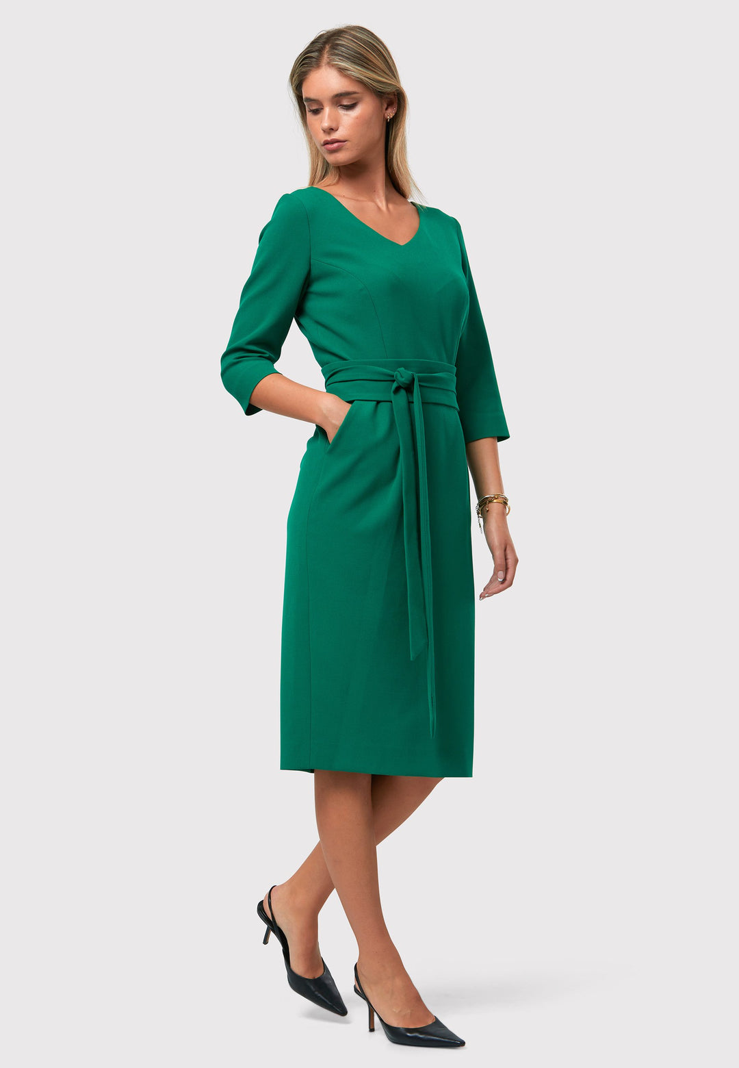 Introducing the Ophelia Dark Emerald Green Dress, a timeless and impeccably tailored silhouette. This expertly crafted dress features a form-flattering design with convenient pockets, a detachable belt, and a pencil skirt that falls to a chic mid-calf length. The sophisticated V-neckline adds an elegant touch to the overall look. Crafted from sustainably sourced fibers with a hint of stretch, this dress ensures both comfort and ease of movement. 