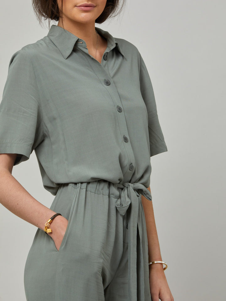 Peggy, a slim-leg jumpsuit in a soft lichen green viscose crepe. Offers a neat button-up collar, belt with a channel and short sleeves. From garden parties to holiday lunches this one-piece has you covered. Designed in Ireland by Helen McAlinden. Made in Europe. Free shipping to the EU & UK.