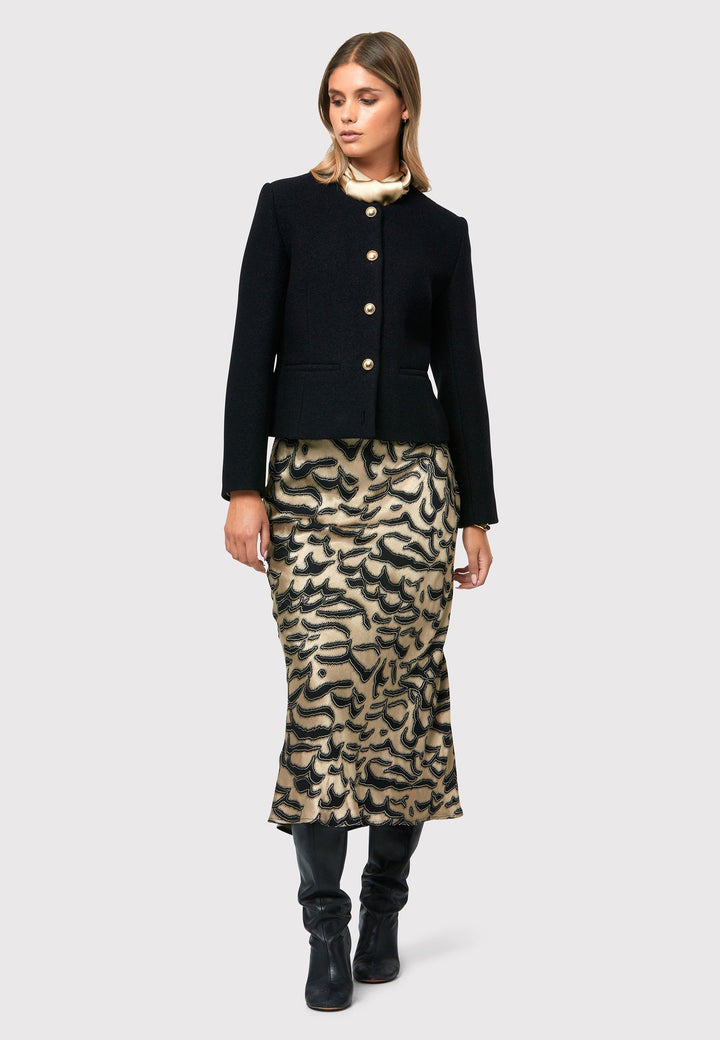 Indulge in the Peyton Devore Bias Skirt, a stylish mid-calf length skirt designed to flatter your figure. With a high-waisted silhouette and a striking black and gold devore patterned satin, it adds a touch of glamour to your look. The form-flattering cut enhances your silhouette, while the side seam zip ensures easy and comfortable wearing. Versatile and chic, the Peyton Devore Bias Skirt is your go-to choice for various occasions, effortlessly elevating your style with a touch of sophistication.