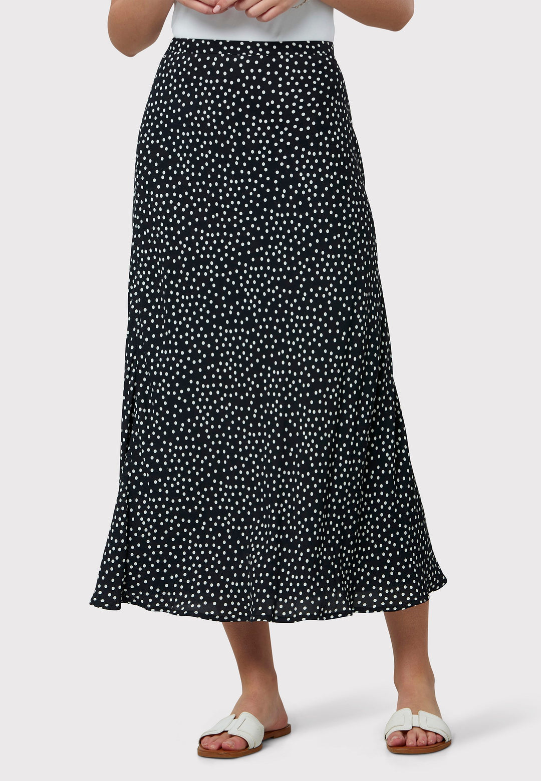 Experience the charm of the Peyton Navy and White Polka Dot Skirt, beautifully crafted with a graceful bias cut for an elegant drape. This mid-calf length design features a flattering high-waisted silhouette in classic navy and white polka dot viscose crepe fabric, echoing 30's glamour.