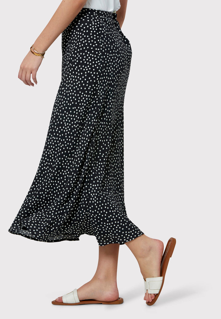 Experience the charm of the Peyton Navy and White Polka Dot Skirt, beautifully crafted with a graceful bias cut for an elegant drape. This mid-calf length design features a flattering high-waisted silhouette in classic navy and white polka dot viscose crepe fabric, echoing 30's glamour.