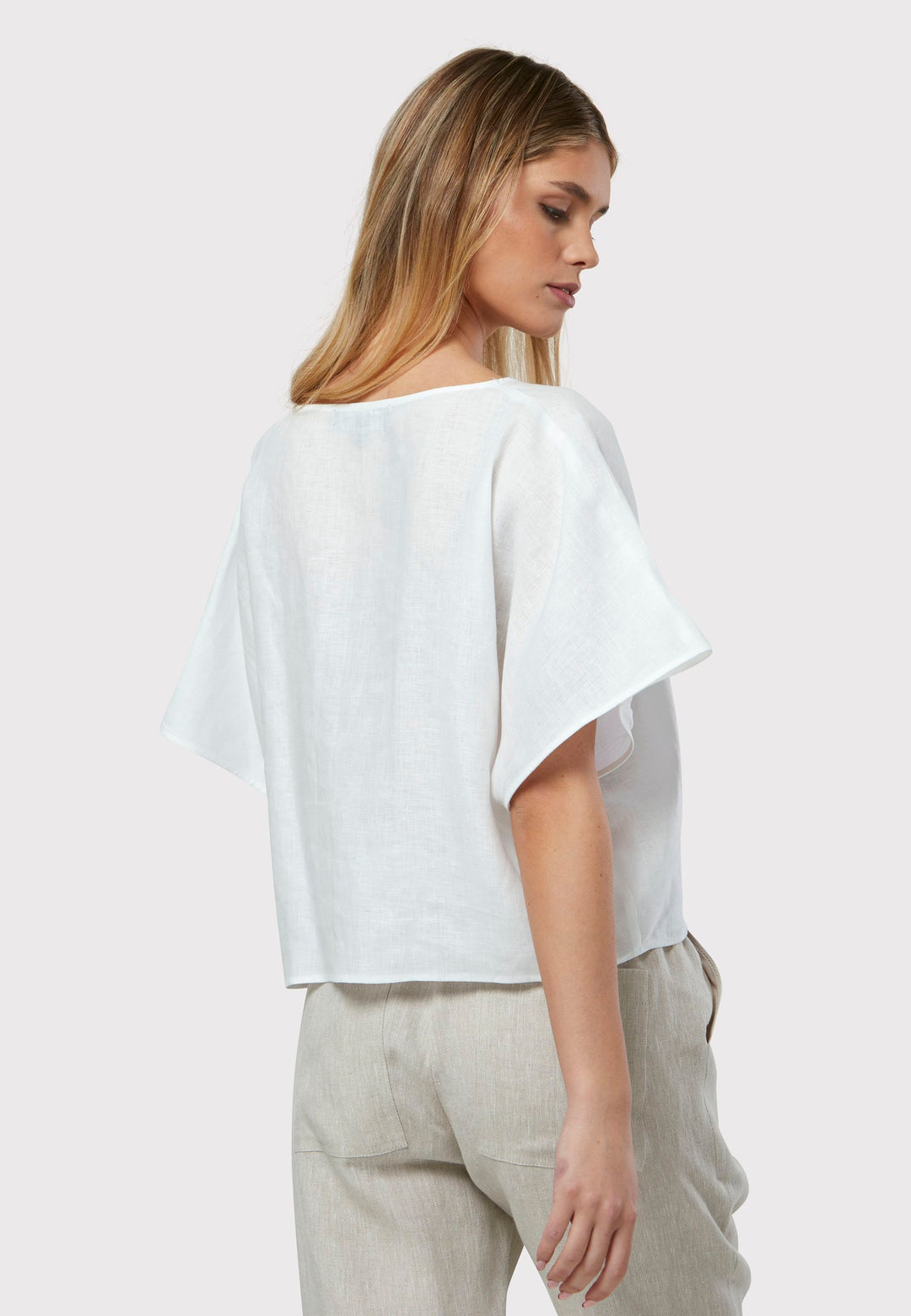 Quinn White Linen Shirt offers an effortless warm-weather look, crafted from breathable pure linen with a flattering v-neck design. Its easy fit ensures summer comfort, complemented by subtle pleat detailing on the back hem for added style.