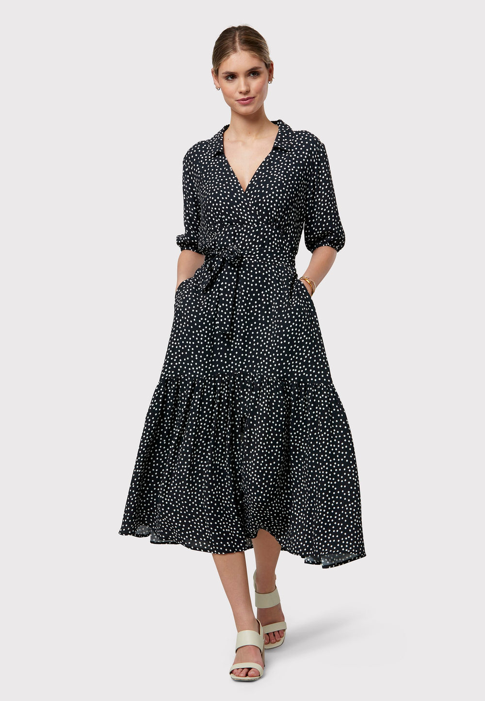 Raquel channels 30's glamour with its classic navy and white polka dot design in our favored viscose crepe. This dress boasts a flattering fit-and-flare skirt and a cross-over V-neckline. A soft belt cinches the waist, offering a customizable look that enhances the figure—whether tied at the front or back, the belt provides styling versatility. Elbow-length sleeves complete the 30's-inspired silhouette, making it a versatile wardrobe essential.