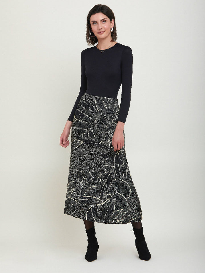 Riley, a simple slip skirt. Crafted in a fluid viscose fabric in an abstract botanical cream on black print. This Hip skimming silhouette flares below the knee & falls to the mid-calf. Helen proposes to style with a cozy sweater or dress up with a timeless black body.