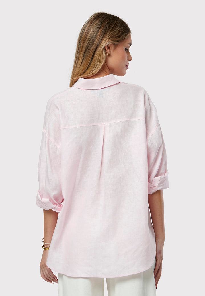 Experience effortless chic with this sustainable linen boyfriend shirt. Featuring an oversized, simplistic design with long sleeves and a classic collar, it exudes timeless appeal. The button-through front and rounded hem combine comfort and style seamlessly, making it a versatile wardrobe staple. Presented in a charming candy pink tone.