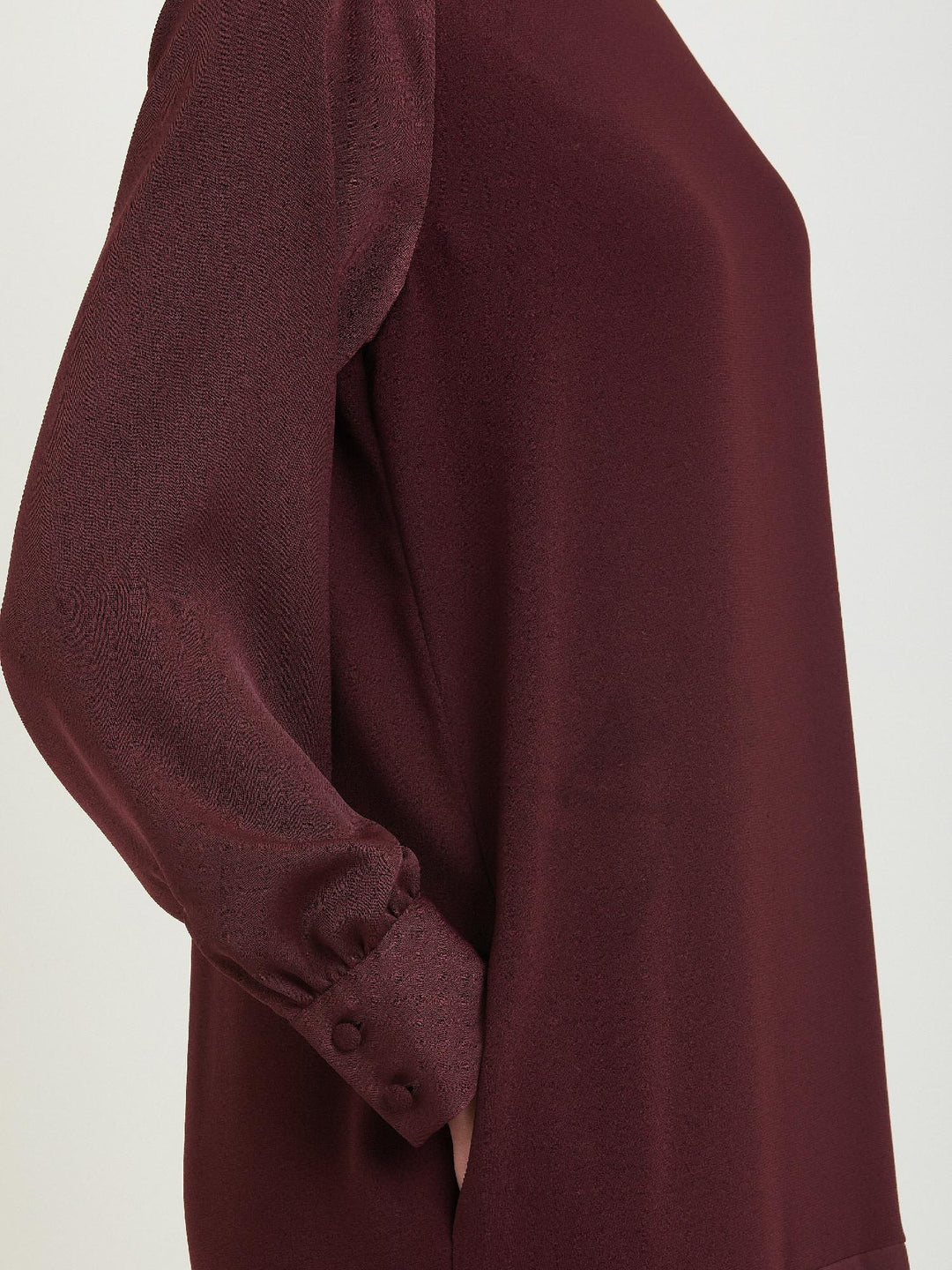 Sarah, a simple easy-fit shift dress. Crafted in a satin back crepe in rich burgundy. Features a satin raglan sleeve & a deep satin band at the hem which adds elegance to this versatile piece. Offers handy side seam pockets for added comfort and functionality. A fresh take on occasion wear.
