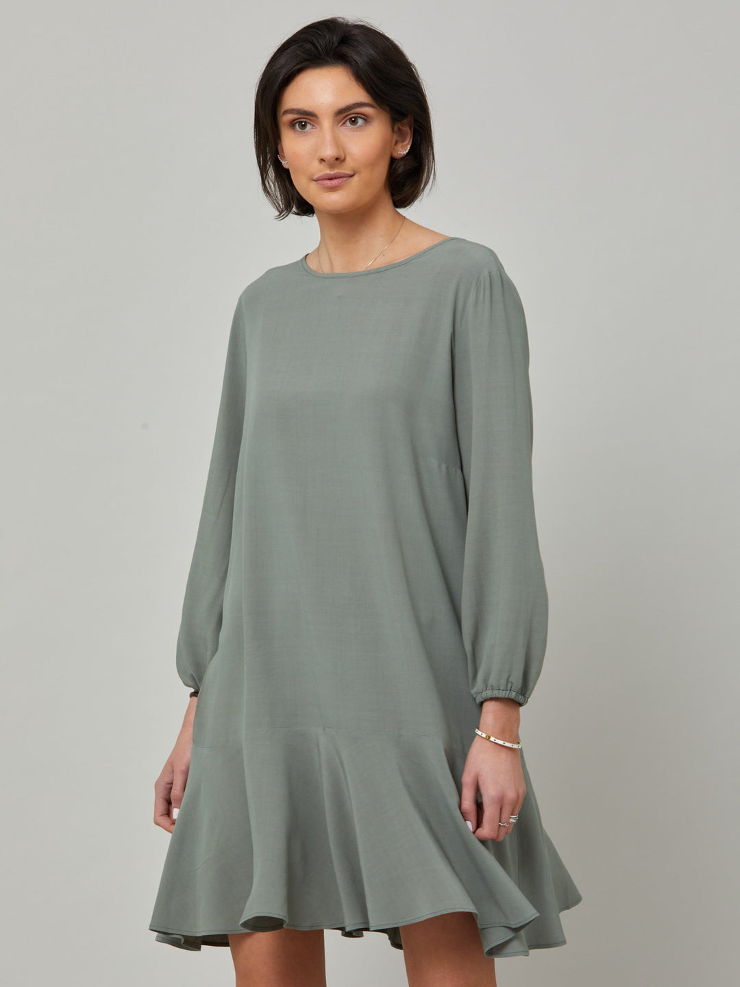Sheila, a great everyday dress. Crafted in our fluid lichen green viscose crepe. A flirty knee-grazing shift dress with a soft elasticated cuff sleeve that falls to a deep frill hem with a jewel neckline and key-hole back detail. For everyday comfort style with trainers. Elevate your mood with this fun piece.