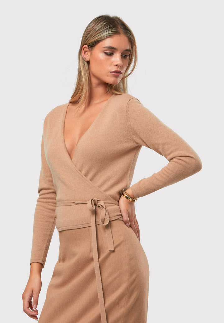 The Siena Camel Cashmere Ballet Wrap is a versatile cardigan designed with a true wrap style. It features full-length sleeves and offers multiple styling options. You can wear it to the front with a V-neckline or to the back with a high neckline and a V-back detail. Made from luxurious cashmere, this wrap can also be layered over the matching Mariena Sleeveless Top for a coordinated and chic ensemble. Embrace the versatility and timeless elegance of the Ballet Wrap.