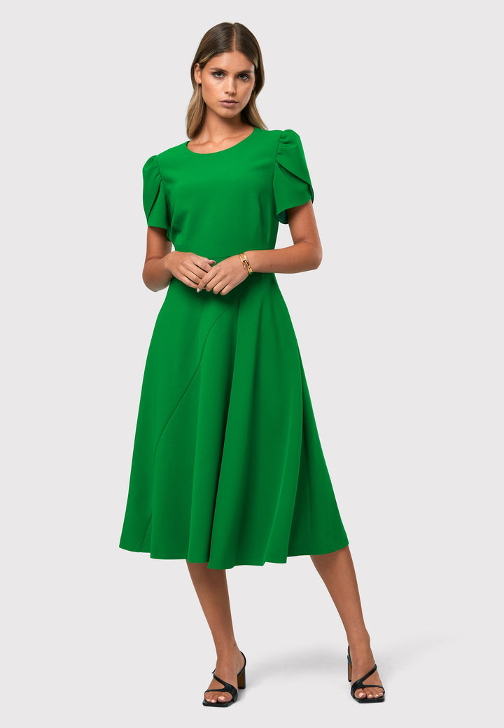 Introducing the Vera Kelly Green Dress, a captivating fit and flare ensemble that effortlessly combines timeless elegance with modern charm. This dress boasts an A-line skirt that creates a graceful and feminine silhouette, while its detailed overlap short sleeves add a unique and stylish touch to the design. With its form-flattering fit, this dress accentuates your curves in all the right places, making it perfect for weddings and other special occasions. 