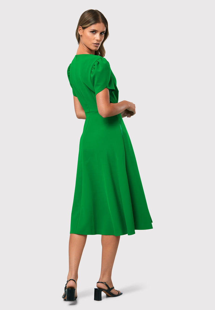 Introducing the Vera Kelly Green Dress, a captivating fit and flare ensemble that effortlessly combines timeless elegance with modern charm. This dress boasts an A-line skirt that creates a graceful and feminine silhouette, while its detailed overlap short sleeves add a unique and stylish touch to the design. With its form-flattering fit, this dress accentuates your curves in all the right places, making it perfect for weddings and other special occasions. 