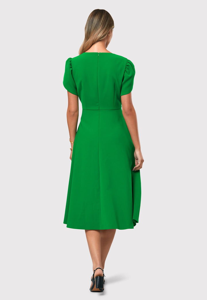 Introducing the Vera Kelly Green Dress, a captivating fit and flare ensemble that effortlessly combines timeless elegance with modern charm. This dress boasts an A-line skirt that creates a graceful and feminine silhouette, while its detailed overlap short sleeves add a unique and stylish touch to the design. With its form-flattering fit, this dress accentuates your curves in all the right places, making it perfect for weddings and other special occasions. 