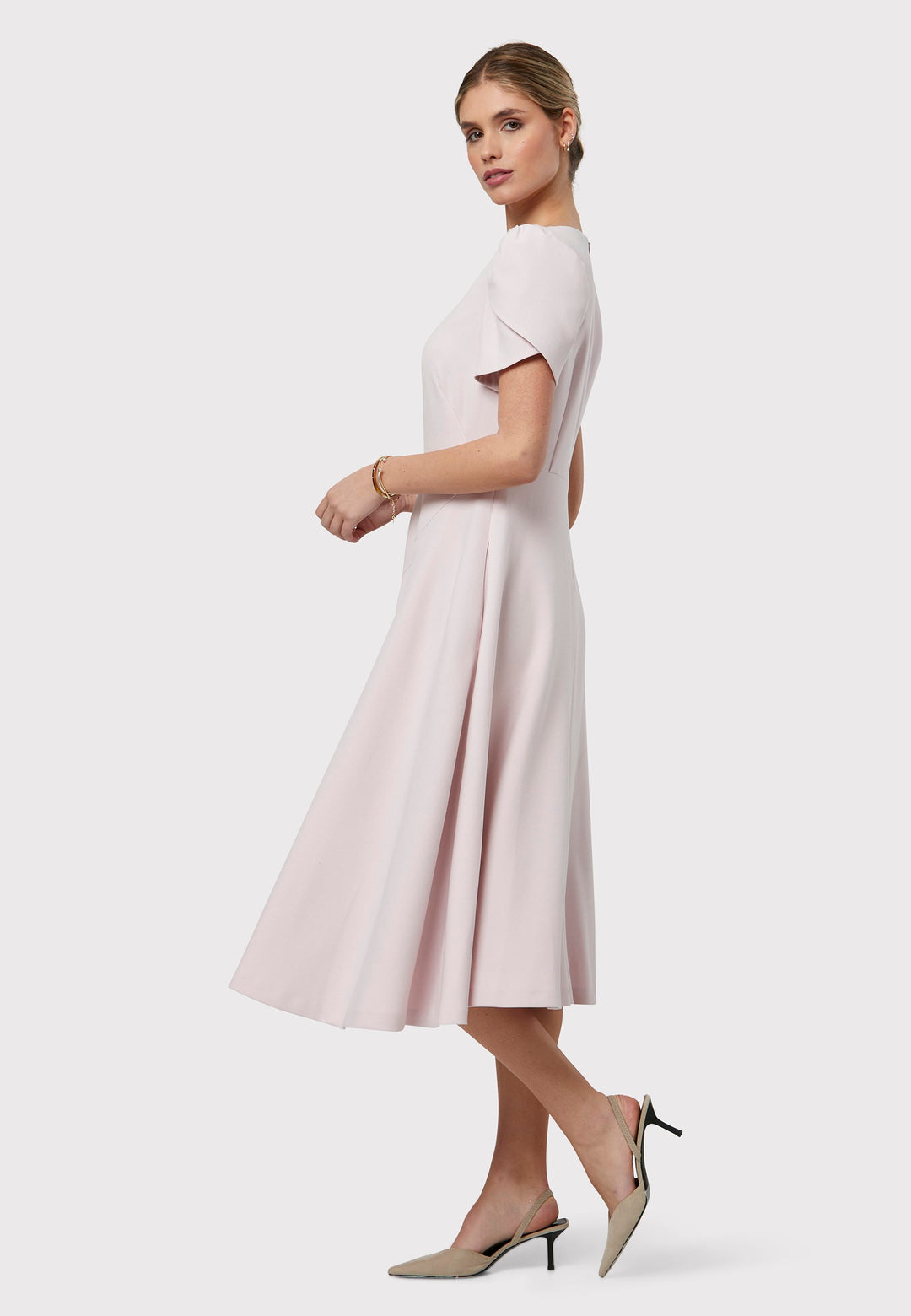 The Vera Soft Pink Dress is a captivating fit-and-flare piece. This feminine round-neck dress showcases a flared skirt that falls to a flattering mid-calf length, complete with practical pockets. The sleeves are adorned with intricate overlapping details, adding a unique touch of interest.
