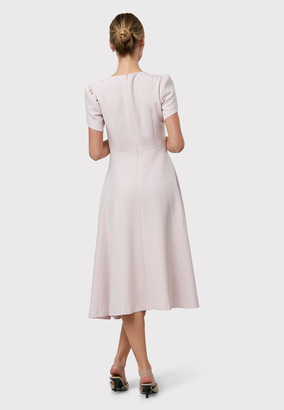 The Vera Soft Pink Dress is a captivating fit-and-flare piece. This feminine round-neck dress showcases a flared skirt that falls to a flattering mid-calf length, complete with practical pockets. The sleeves are adorned with intricate overlapping details, adding a unique touch of interest.
