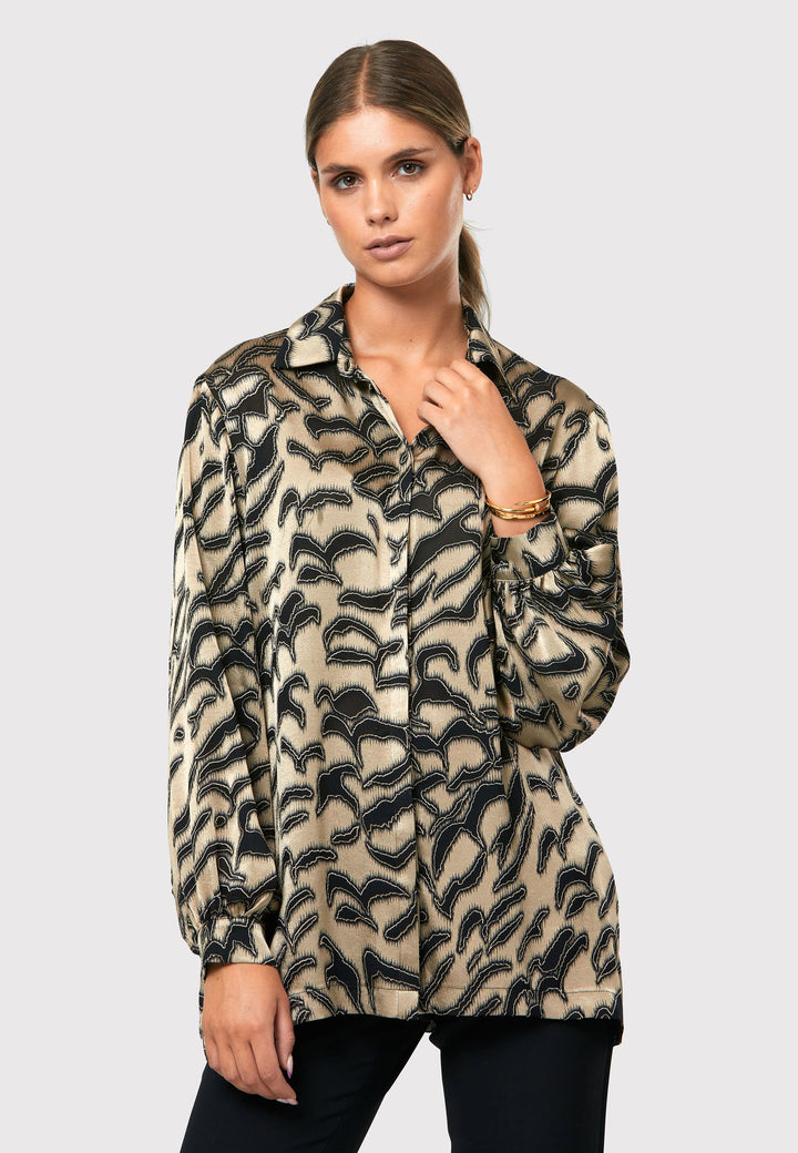 Introducing the Viola Devore Shirt, a stunning and luxurious piece that will make a statement in your wardrobe. This shirt features a captivating gold satin fabric adorned with black abstract details, creating a visually striking design. The voluminous sleeves elegantly flow into a tight buttoned cuff, adding a touch of sophistication. With its slightly dropped shoulders, this shirt offers a relaxed yet stylish fit. 