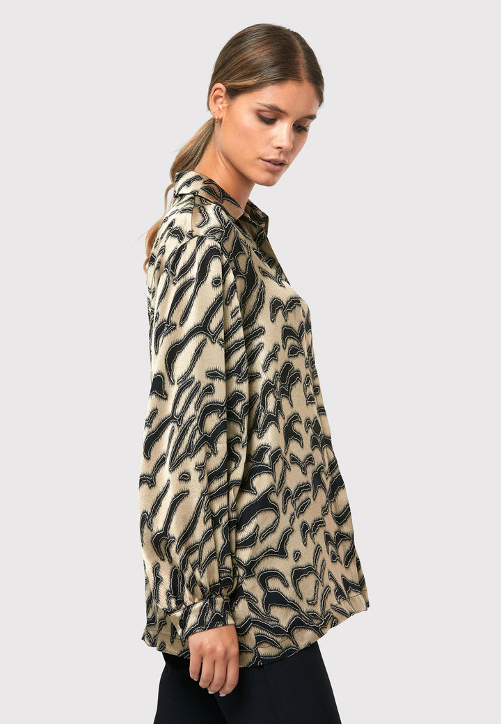 Introducing the Viola Devore Shirt, a stunning and luxurious piece that will make a statement in your wardrobe. This shirt features a captivating gold satin fabric adorned with black abstract details, creating a visually striking design. The voluminous sleeves elegantly flow into a tight buttoned cuff, adding a touch of sophistication. With its slightly dropped shoulders, this shirt offers a relaxed yet stylish fit. 