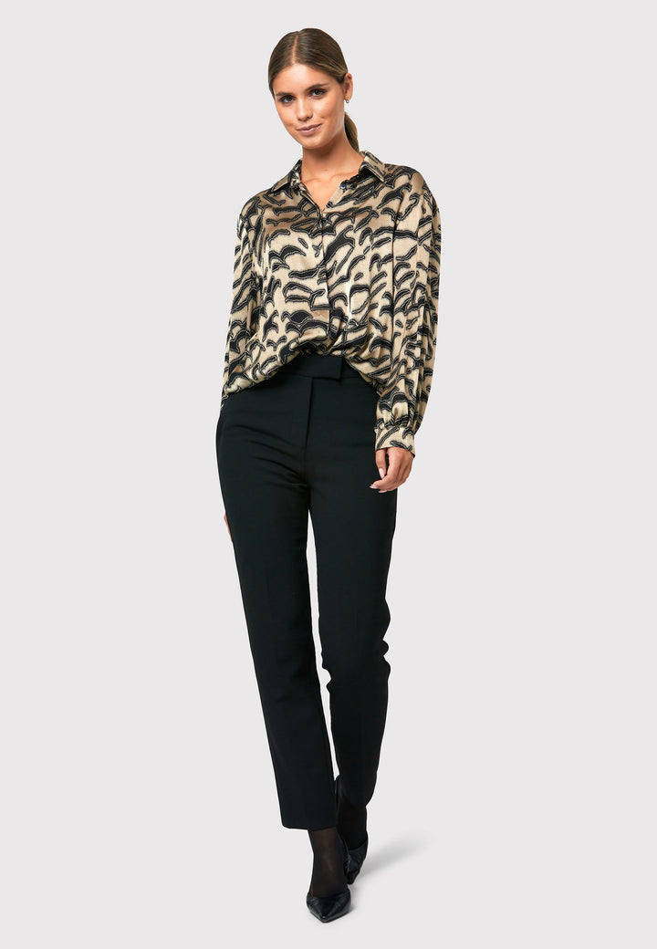Introducing the Viola Devore Shirt, a stunning and luxurious piece that will make a statement in your wardrobe. This shirt features a captivating gold satin fabric adorned with black abstract details, creating a visually striking design. The voluminous sleeves elegantly flow into a tight buttoned cuff, adding a touch of sophistication. With its slightly dropped shoulders, this shirt offers a relaxed yet stylish fit. 