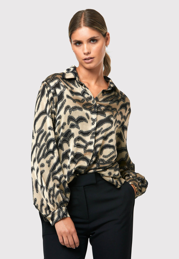 Introducing the Viola Devore Shirt, a stunning and luxurious piece that will make a statement in your wardrobe. This shirt features a captivating gold satin fabric adorned with black abstract details, creating a visually striking design. The voluminous sleeves elegantly flow into a tight buttoned cuff, adding a touch of sophistication. With its slightly dropped shoulders, this shirt offers a relaxed yet stylish fit. 